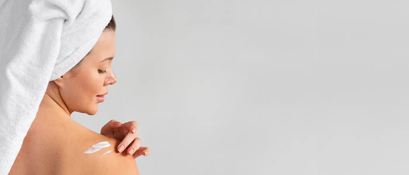 lotion1400x600 woman applying lotion cream to her shoulder