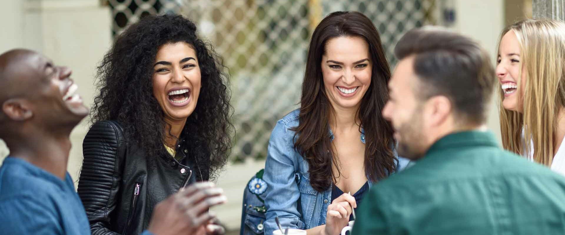 adults laughing while having coffee together